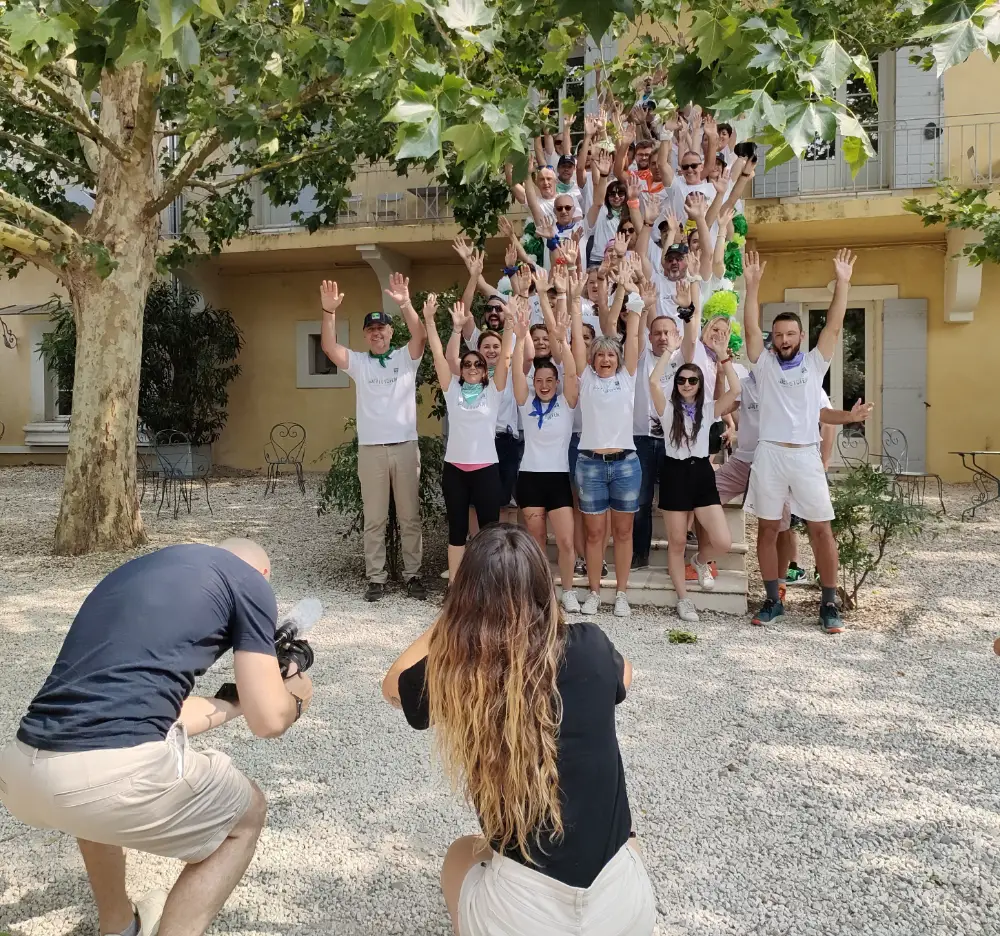 Photo de groupe d’entreprise en extérieur sous les arbres, tous les bras levés