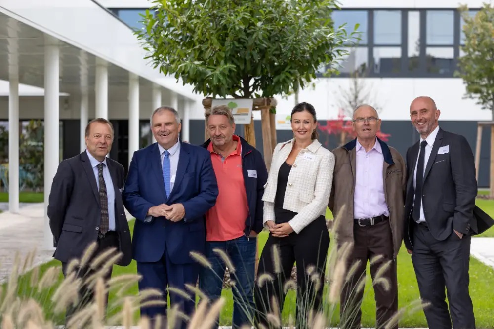 Photo officielle d'équipe lors d'une convention d'entreprise à Troyes, dans un cadre verdoyant et moderne
