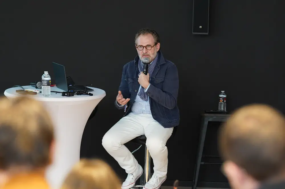 Conférencier assis avec micro lors d’un moment d’échange avec les collaborateurs à Auxerre