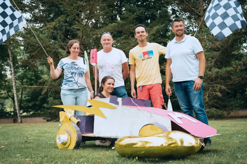 Équipe rassemblée autour d’un bolide en carton lors d’une animation de convention à Tours