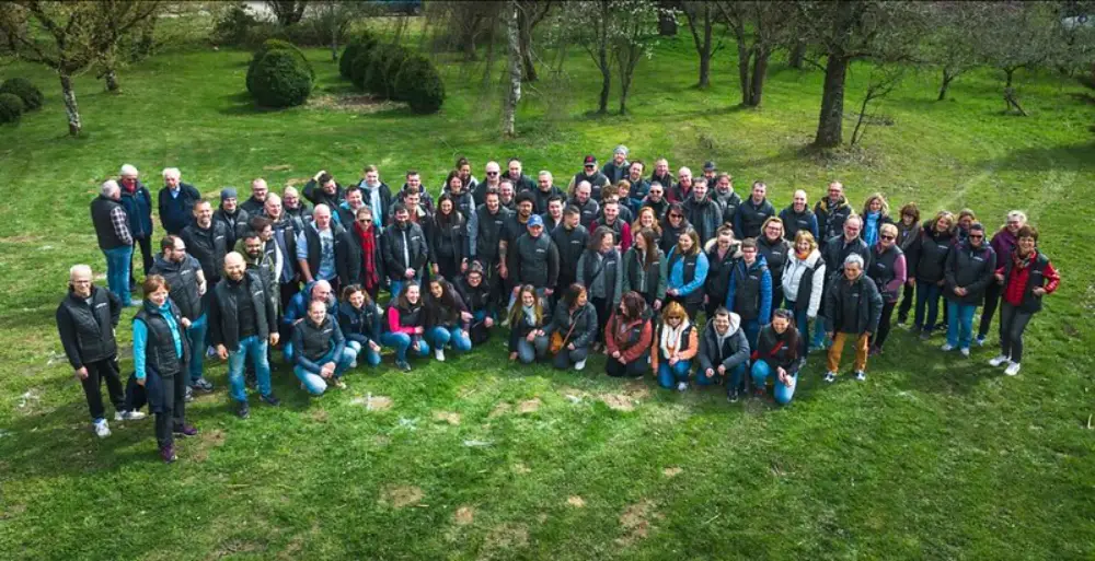 Photo de groupe d’une équipe réunie dans un cadre verdoyant lors d’une convention annuelle
