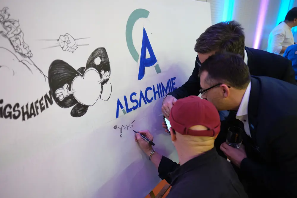Mur de graff participatif co-créé par les invités d’un événement d’entreprise avec le logo Alsachimie et des dessins à main levée