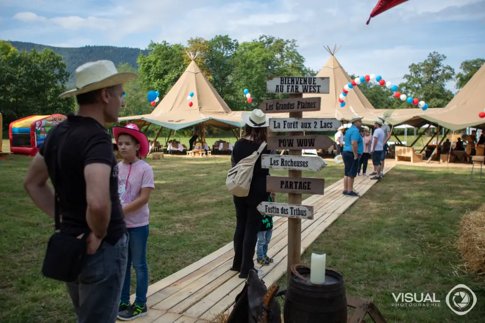 Décoration événementielle thématique western avec tentes tipi et panneaux en bois personnalisés