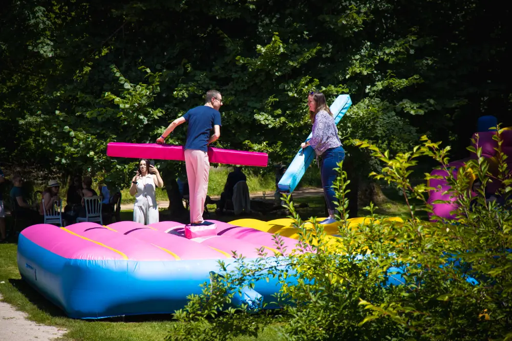 Animation ludique en plein air pendant une Summer Party d’entreprise avec joute gonflable colorée