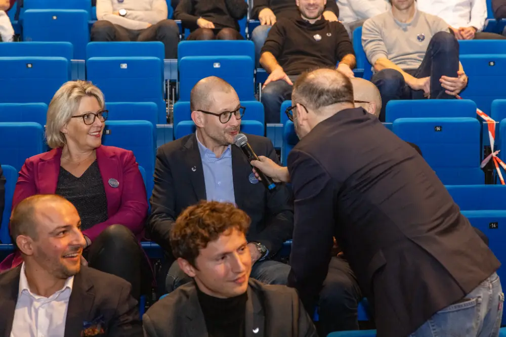 Intervenant interviewant un participant dans la salle lors d’une convention d’entreprise à Strasbourg