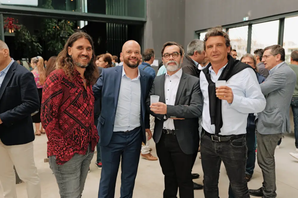 Groupe de quatre hommes posant souriants avec leurs verres pendant une soirée d’entreprise à Pau.
