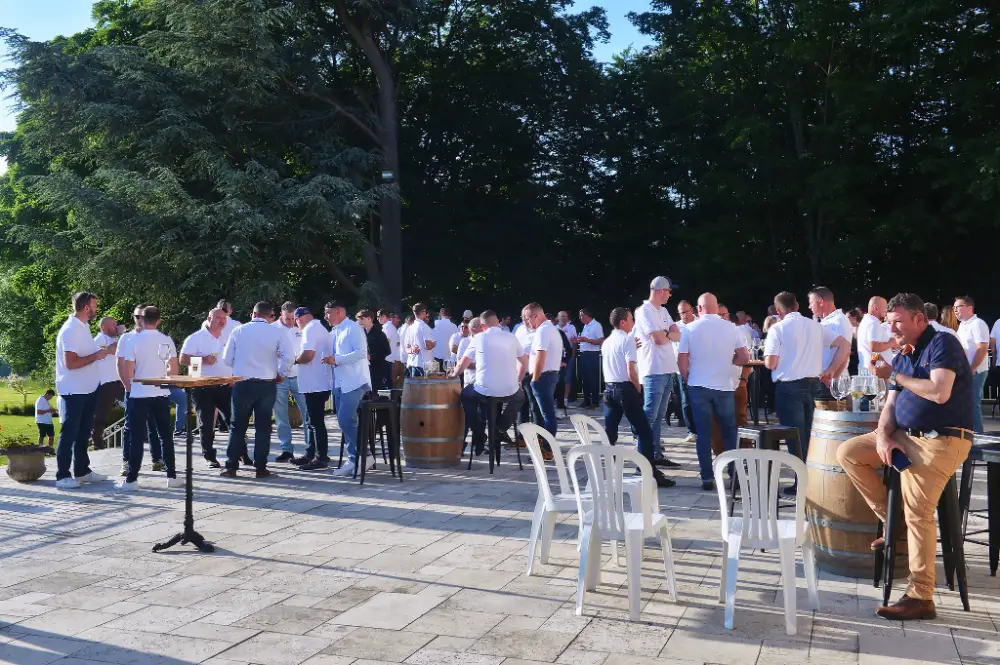 Cocktail dînatoire en plein air avec des équipes en tenue blanche, organisé dans un cadre arboré.