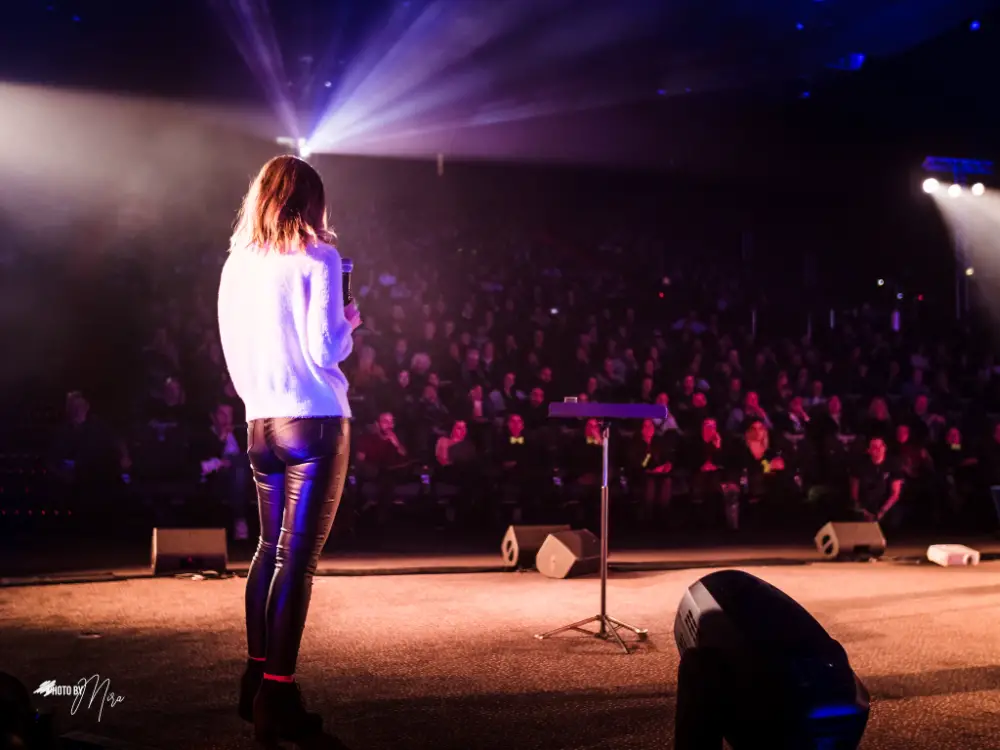 Conférencière sur scène face à un public captivé pendant une convention à Nevers