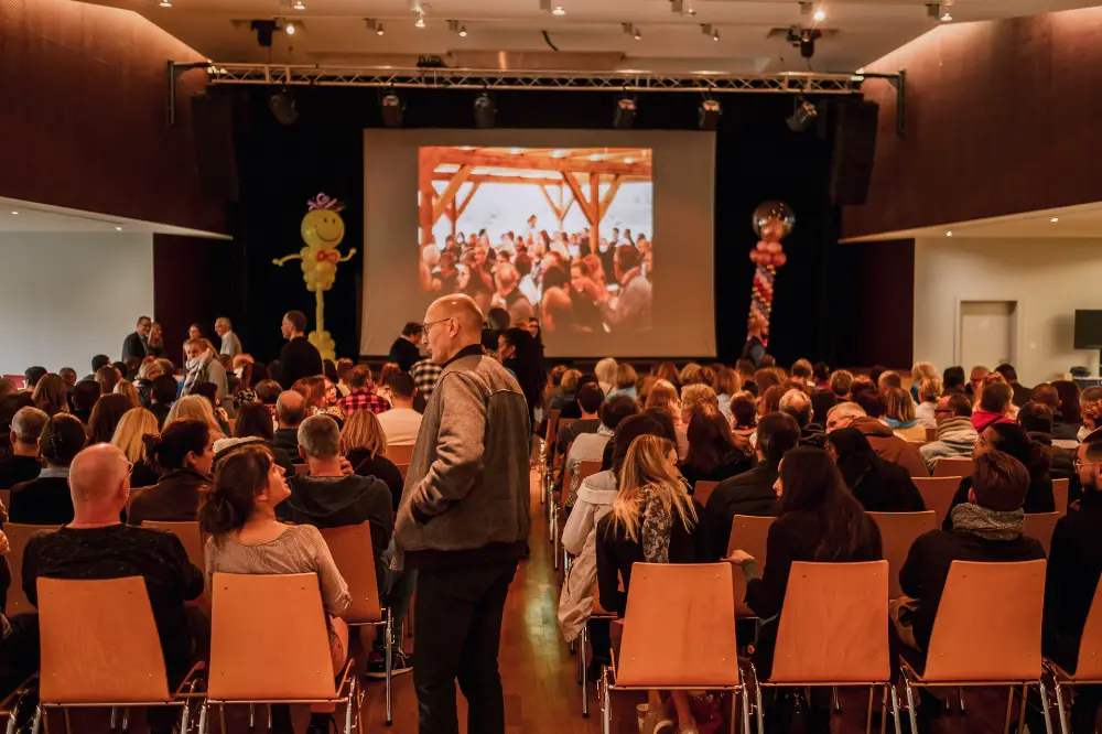 Salle comble lors d’une projection pendant une convention d’entreprise conviviale