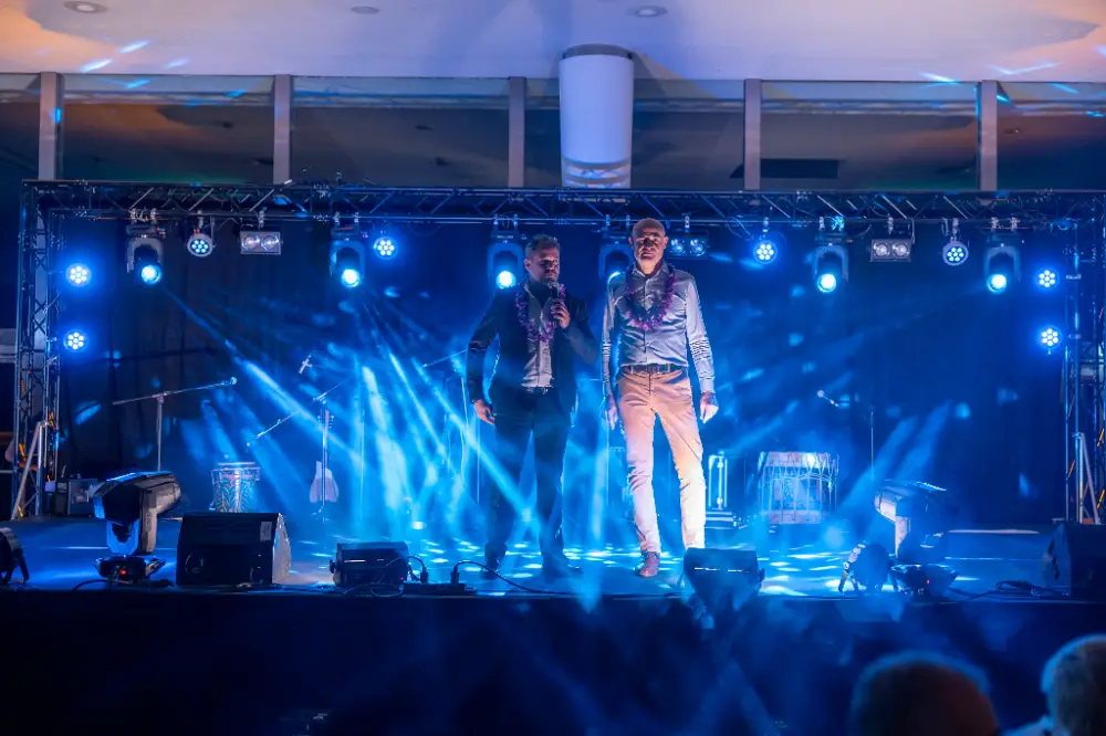 Deux animateurs sur scène lors d’une soirée de convention d’entreprise à Strasbourg, sous jeux de lumière bleus