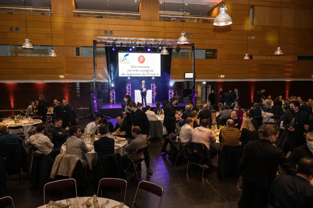 Dîner assis dans une grande salle avec scène et discours d’accueil au Congrès Légumes de France à Nantes.