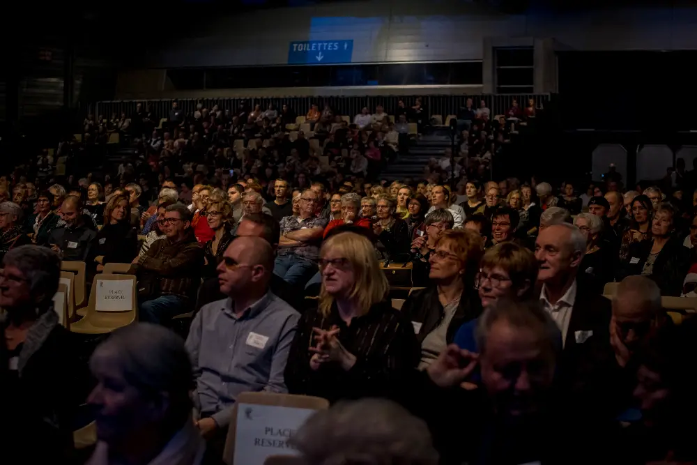 Large audience attending a professional congress in a dimly lit auditorium