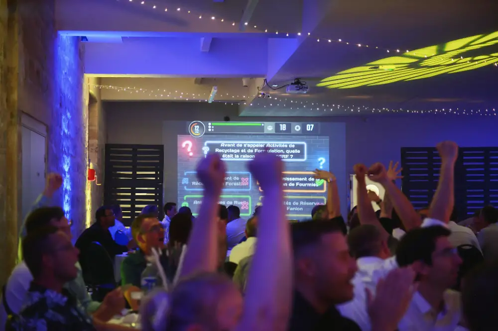 Salle en effervescence pendant un quiz interactif projeté sur écran à une soirée de convention à Reims