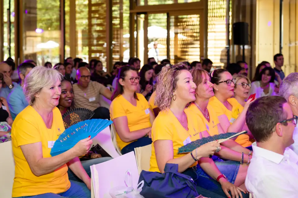 Collaborateurs enthousiastes en t-shirts jaunes participant à une animation ludique pendant une convention