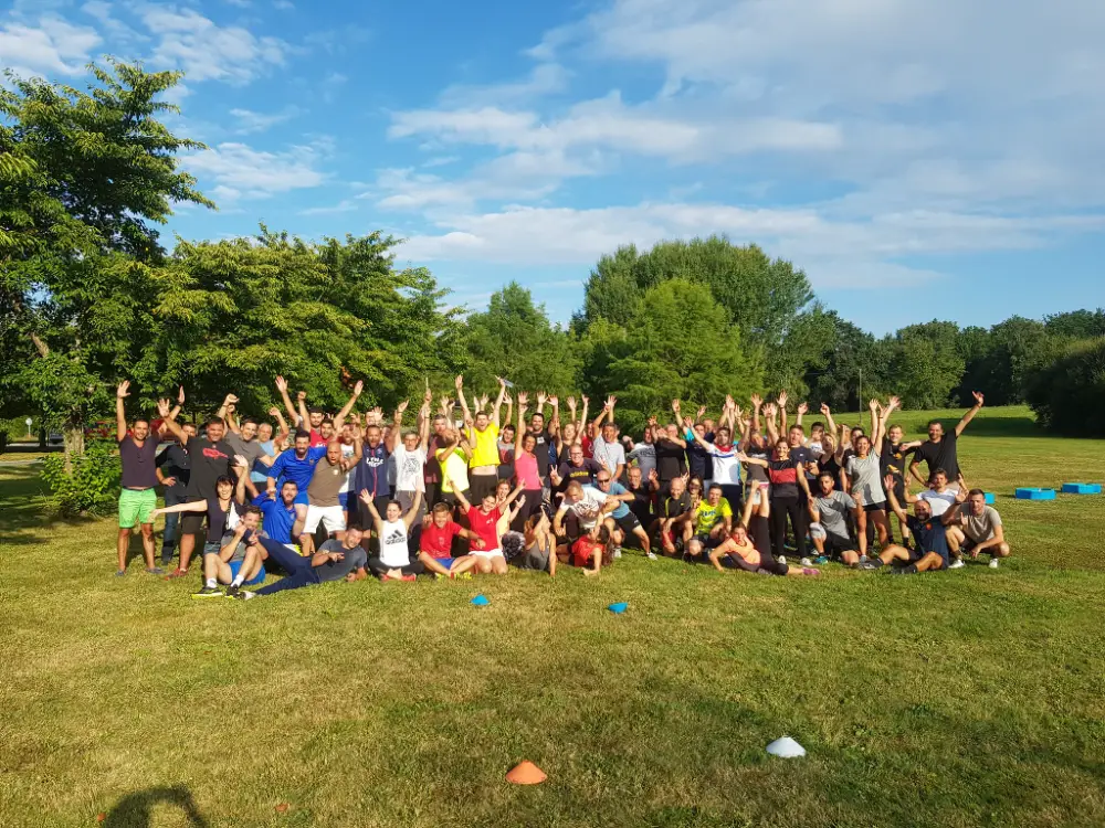 Photo de groupe lors d'une convention d'entreprise à Bordeaux, rassemblant de nombreux participants au bord d’un lac.