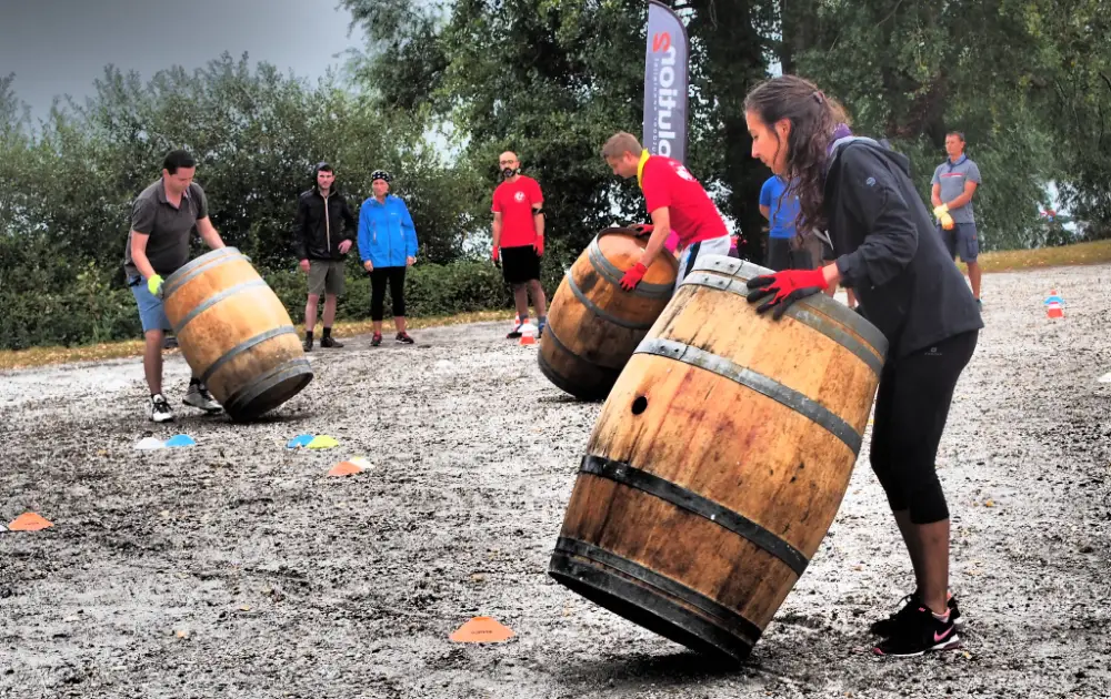 Activité de team building à Bordeaux pendant une convention d'entreprise, avec des participants manipulant des tonneaux en bois.