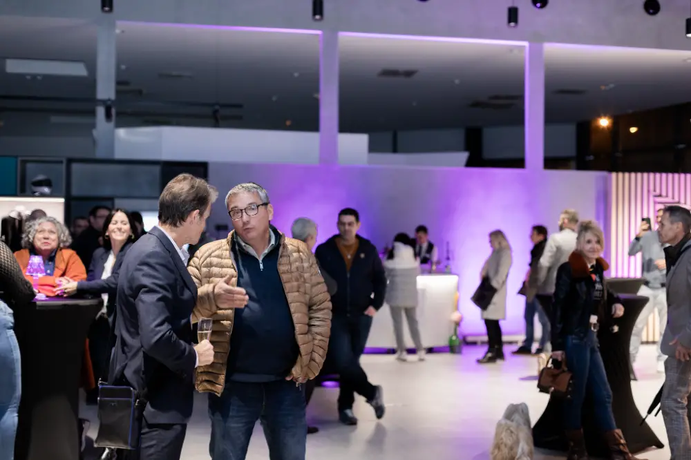 Échange convivial entre professionnels dans un espace événementiel lumineux à Dijon.