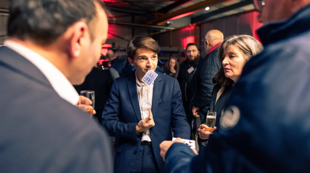 Magicien réalisant un tour de cartes pendant un cocktail de convention entreprise à Saint-Étienne