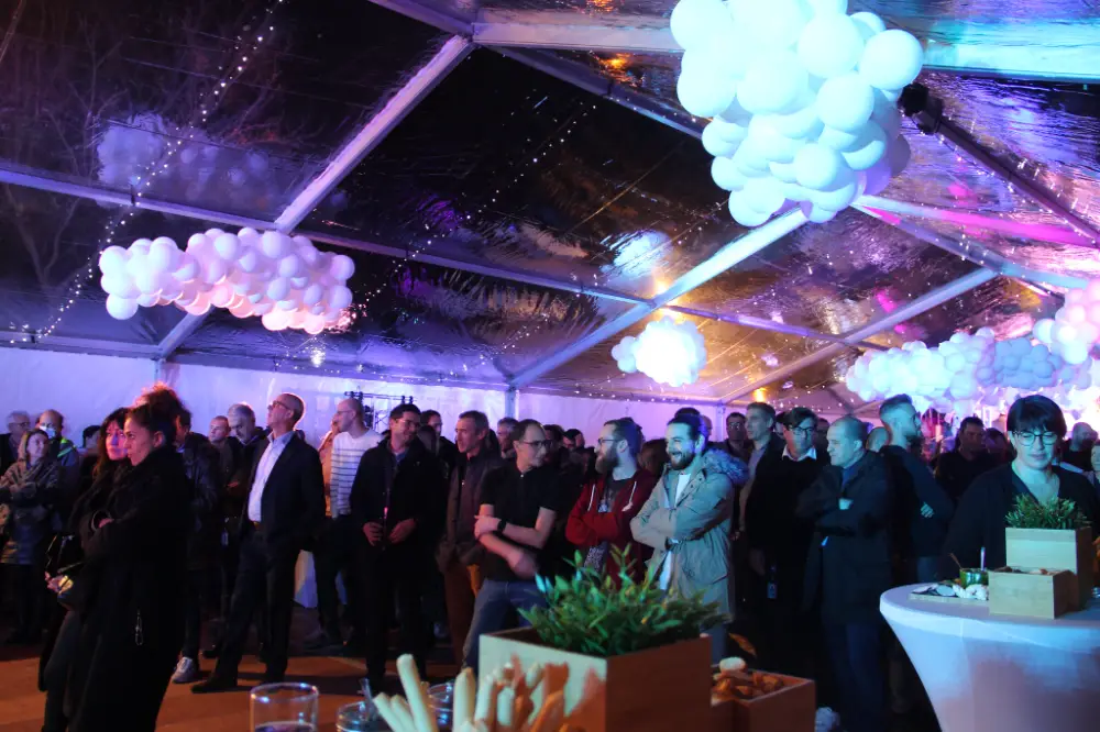 Soirée d’entreprise sous un chapiteau à Marseille, avec ambiance lumineuse et nuages en ballons suspendus