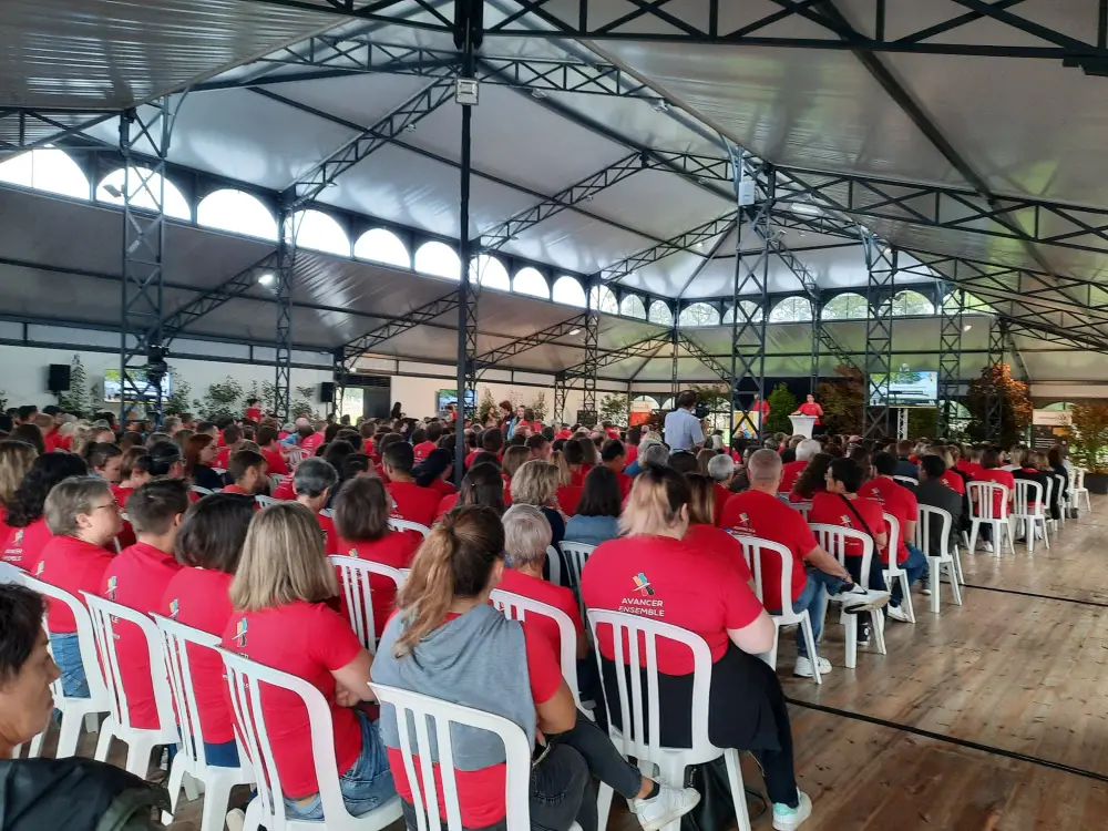 Grande assemblée de collaborateurs en t-shirts rouges assistant à une convention d’entreprise à Bruxelles