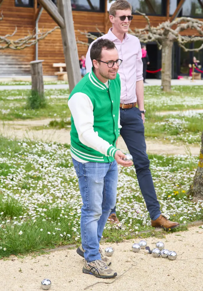 Collaborateur concentré en train de lancer une boule de pétanque lors d’un tournoi d’entreprise