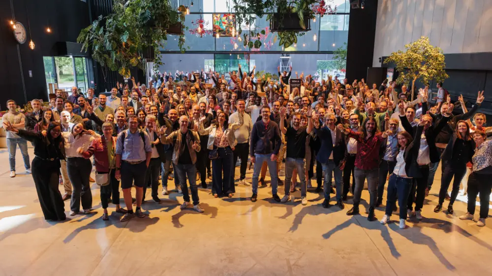 Photo de groupe dynamique de tous les participants à une convention corporate à Genève.