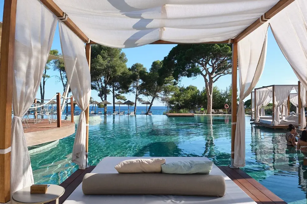 Espace piscine d’un hôtel de luxe à Marseille, avec lits balinais et vue sur la mer